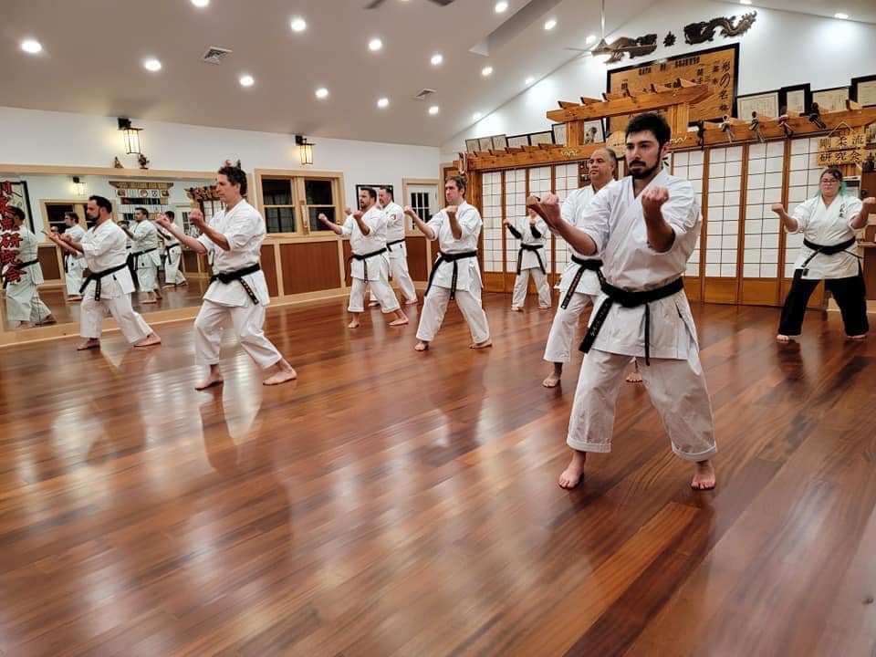 A group of people in white and black uniforms practicing karate.