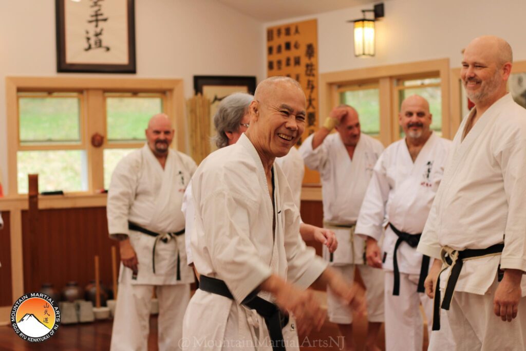 A group of men in white shirts and black belts.