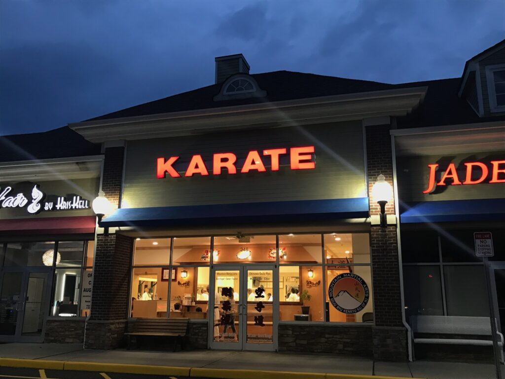 A karate restaurant with lights on the front of it.