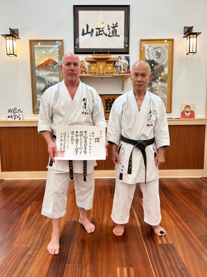 Two men in white and black uniforms holding a board.