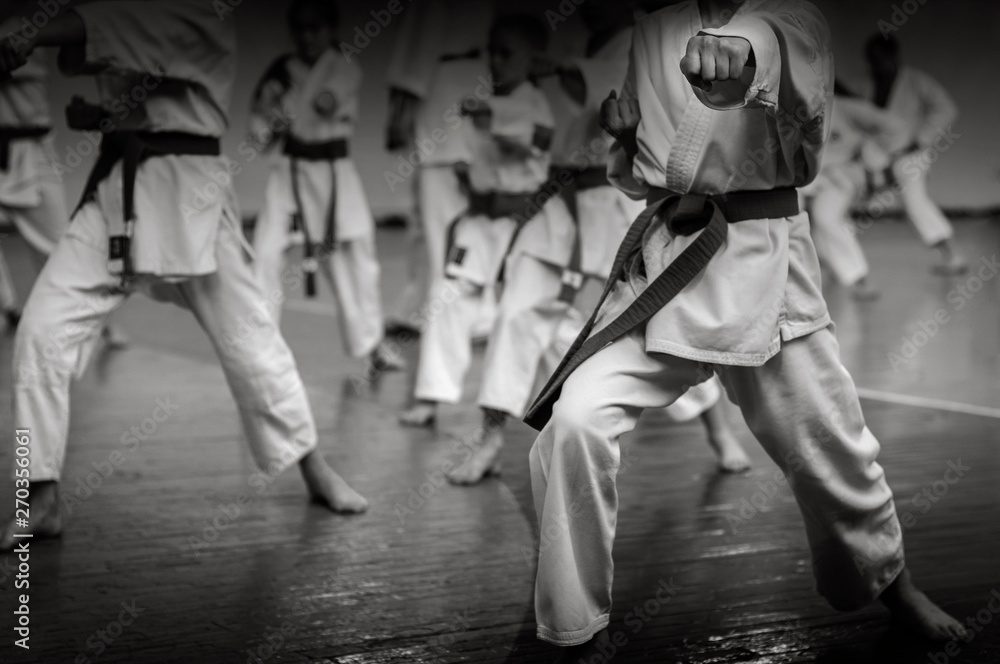 A group of people in white uniforms are practicing karate.