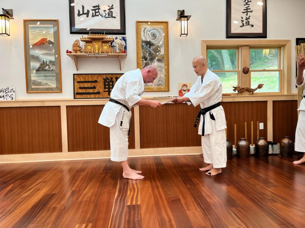 Two men in white and black uniforms practicing martial arts.
